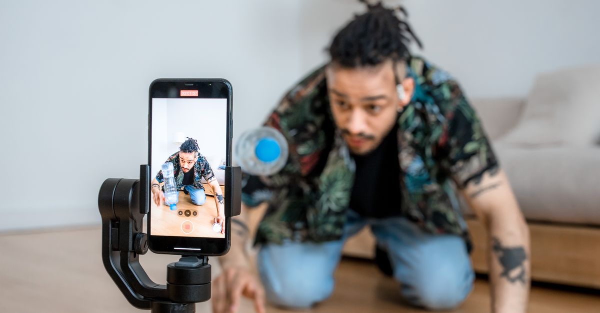 Content creator filming themselves with a smartphone on a gimbal.